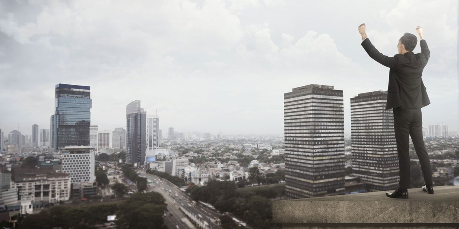 man standing on top of a building looking at the city