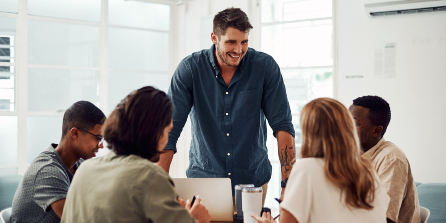 Project manager talking to workers at a desk in an office