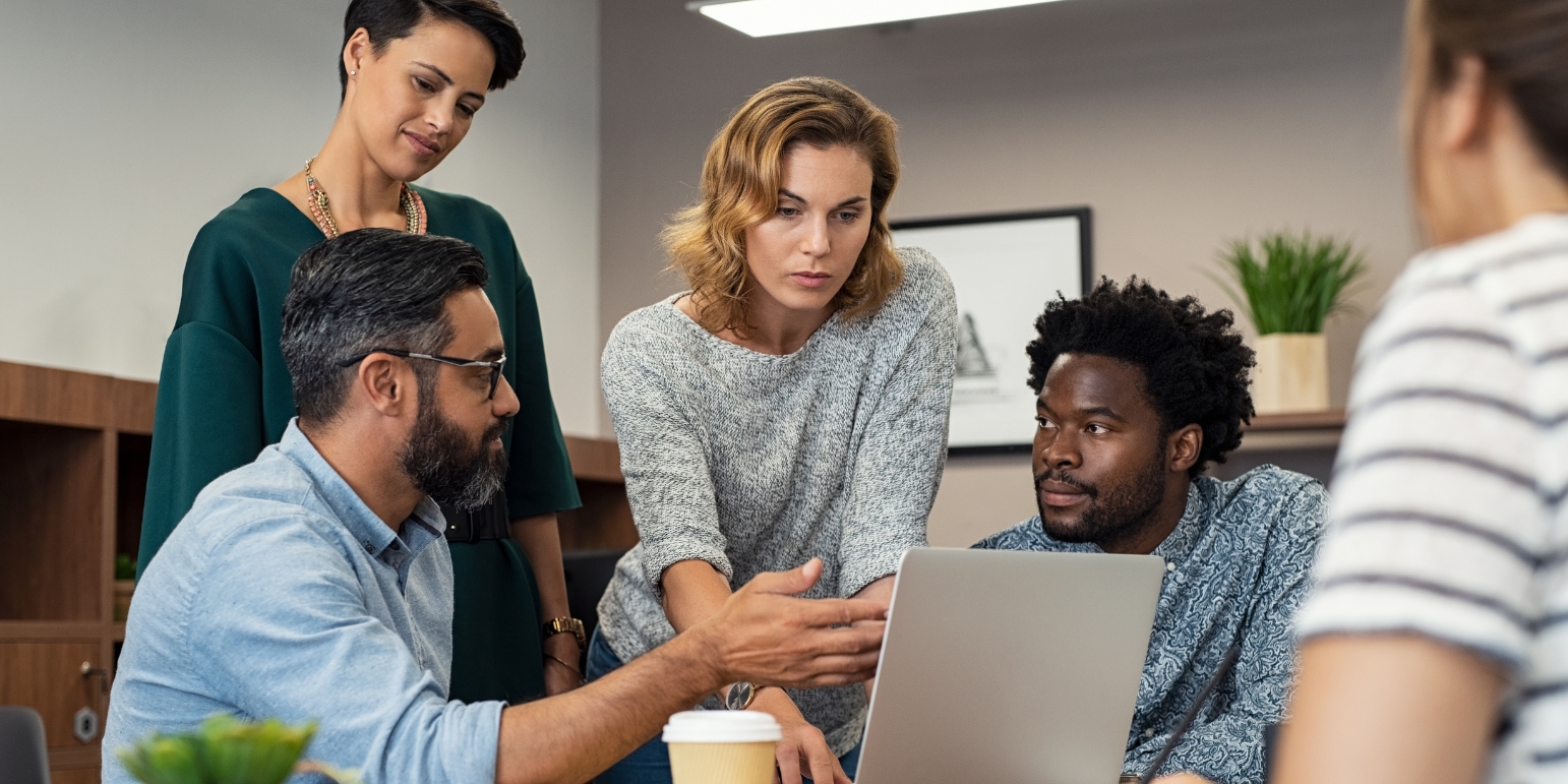 Project managers meeting around a laptop