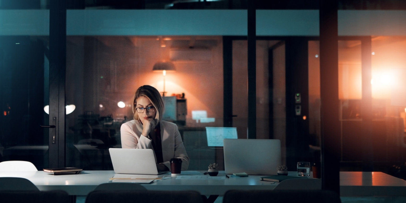 A person at a laptop in a dark office